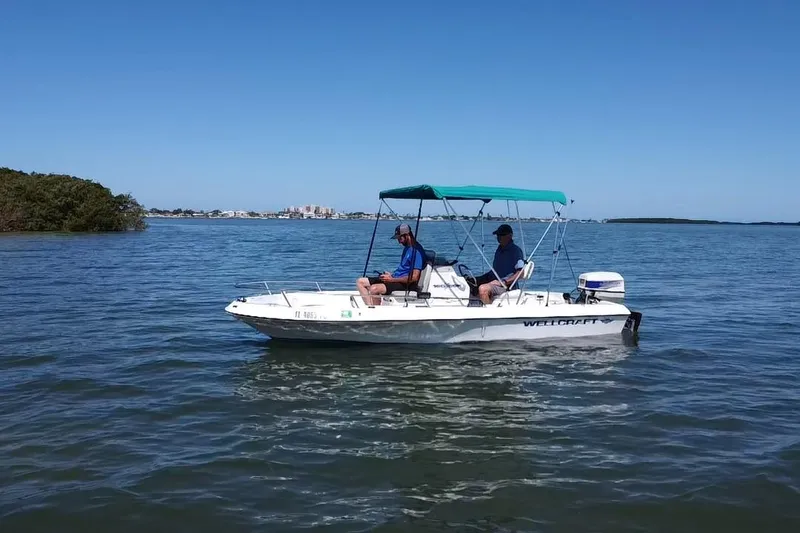 Slide: The Image of 1996 Wellcraft 160 Fisherman boat with two people on calm water. - 16