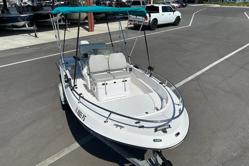Slide: The Image of 1996 Wellcraft 160 Fisherman boat with canopy on trailer in parking lot. - 6