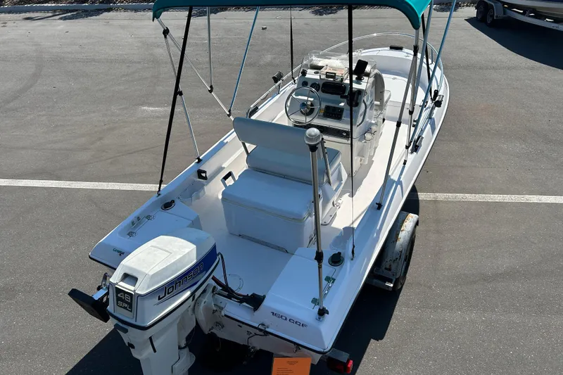 Slide: The Image of 1996 Wellcraft 160 Fisherman boat with Johnson outboard motor, parked on a trailer. - 7