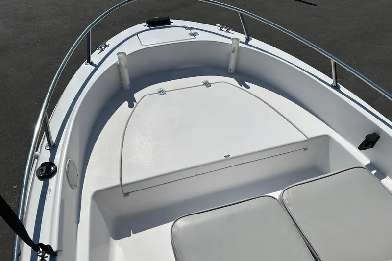 Slide: The Image of 1996 Wellcraft 160 Fisherman boat interior with white seating and storage compartment. - 8