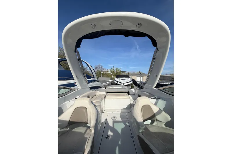 Slide: The Image of 2020 Crownline 286 SC boat interior with seating and open canopy under clear blue sky. - 13