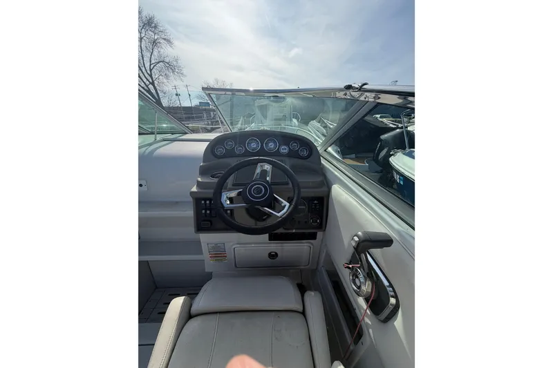 Slide: The Image of 2020 Crownline 286 SC boat cockpit with steering wheel and control panel. - 16