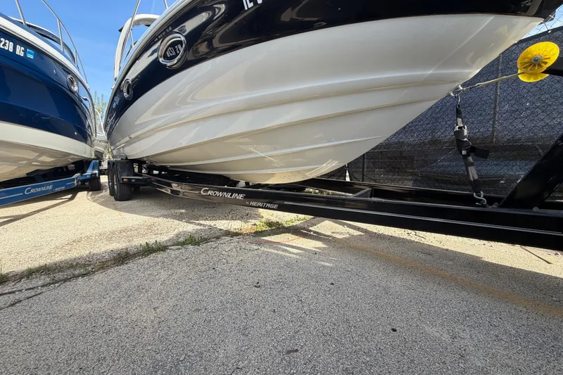 Slide: The Image of 2020 Crownline 286 SC boat on trailer, parked outdoors, showcasing sleek hull design. - 20