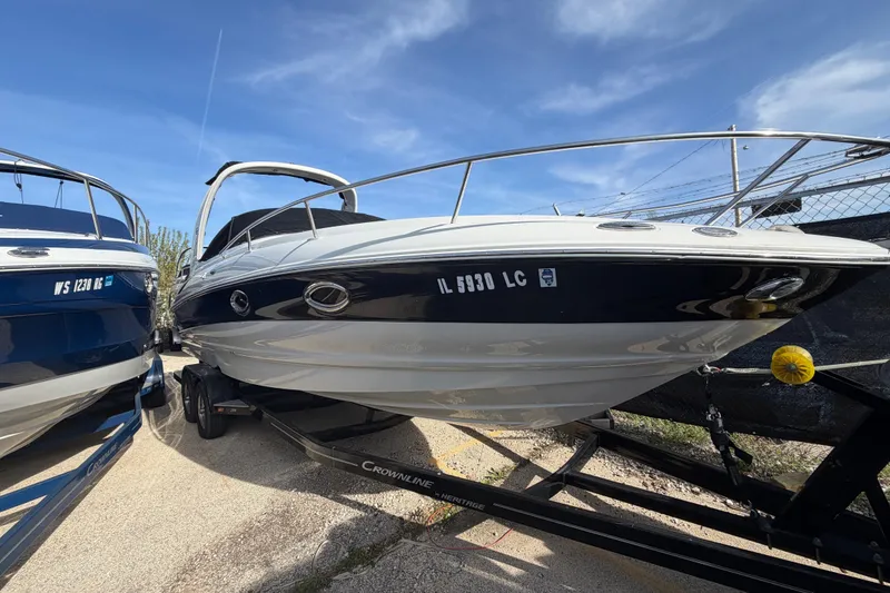 Slide: The Image of 2020 Crownline 286 SC boat on trailer under clear blue sky. - 23