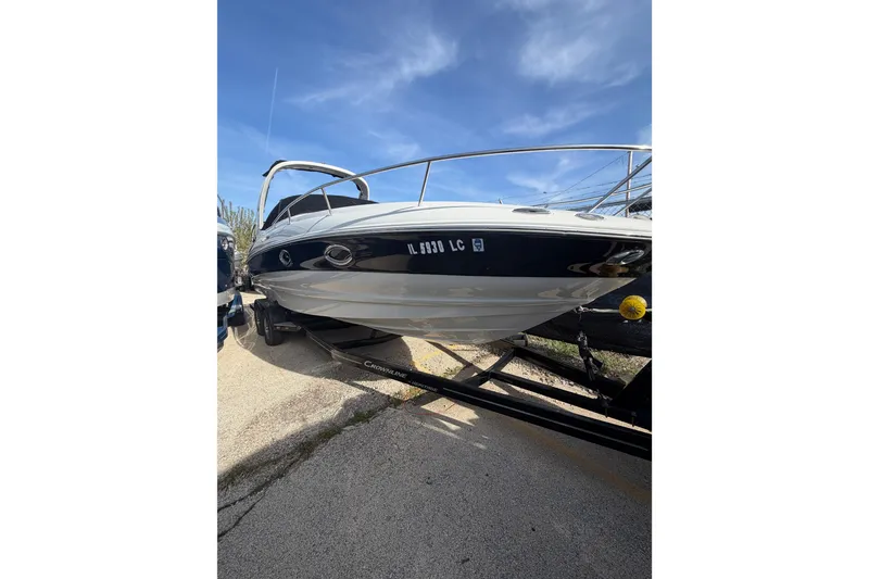 Slide: The Image of 2020 Crownline 286 SC boat on trailer under clear blue sky. - 24