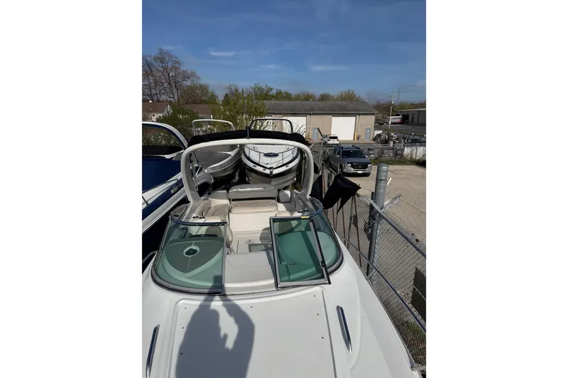 Slide: The Image of 2020 Crownline 286 SC boat with open cockpit and windshield, parked outdoors. - 4