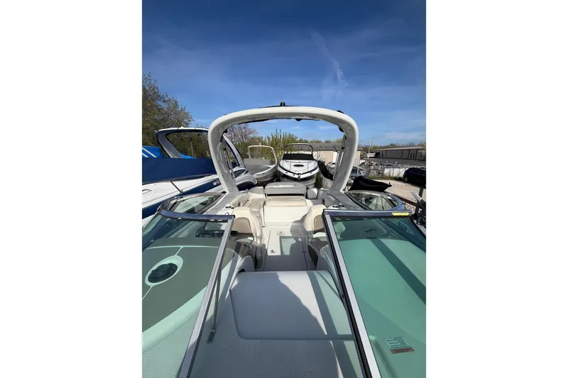 Slide: The Image of 2020 Crownline 286 SC boat with open deck and sleek design under clear blue sky. - 6