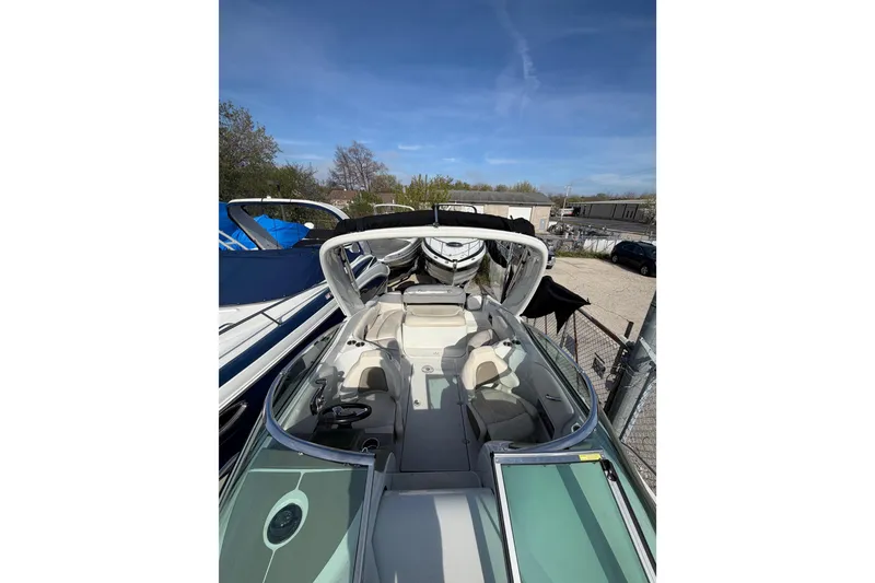Slide: The Image of 2020 Crownline 286 SC boat interior with open cockpit and seating, parked outdoors. - 7