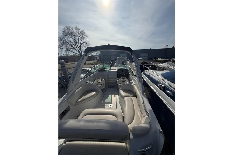 Slide: The Image of 2020 Crownline 286 SC boat interior with seating and helm, under sunny sky. - 9
