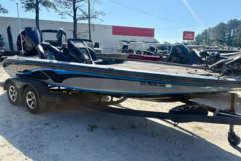 Slide: The Image of 2022 Nitro Z20 boat on trailer, parked outdoors, with trees and storage facility in background. - 4