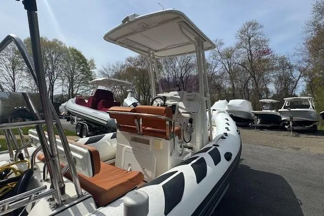 Slide: The Image of 2019 Brig Navigator 570 inflatable boat with canopy, parked outdoors among other boats. - 2