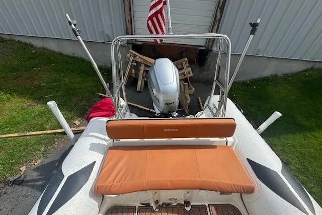 Slide: The Image of 2019 Brig Navigator 570 boat with Yamaha 100 engine, featuring tan seating and American flag. - 5