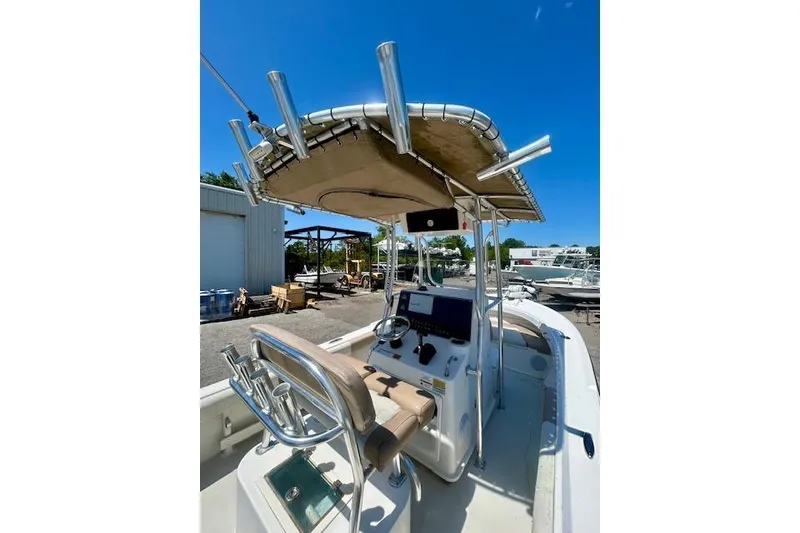 Slide: The Image of 2019 Parker 21 Special Edition boat with T-top and console in a marina setting. - 4