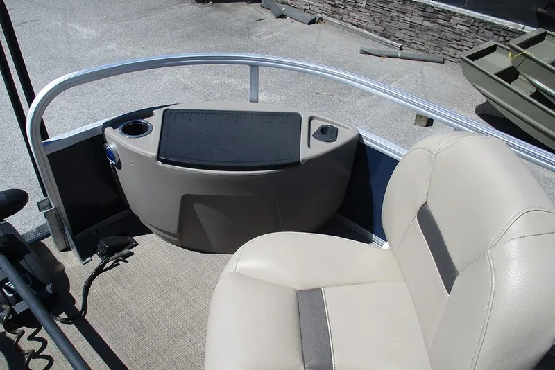 Slide: The Image of 2023 Sun Tracker Bass Buggy 18 DLX interior with beige seating and control panel. - 11