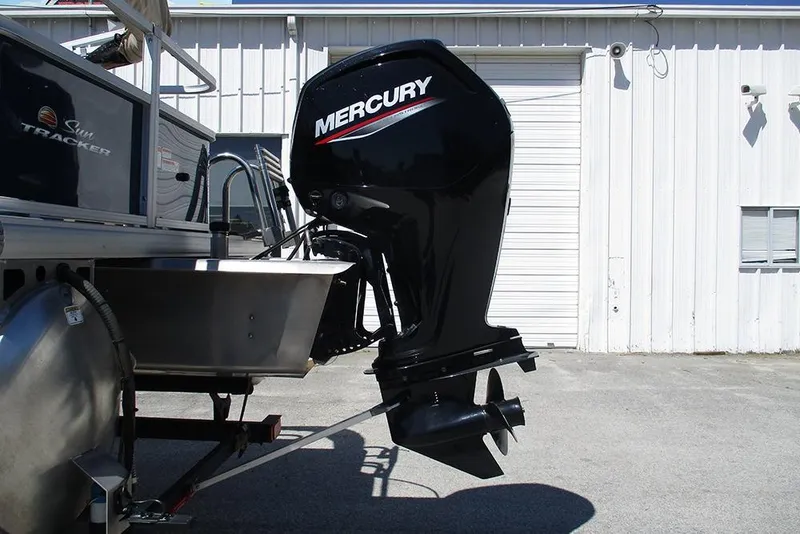 Slide: The Image of 2023 Sun Tracker Bass Buggy 18 DLX with Mercury outboard motor in a parking lot. - 9