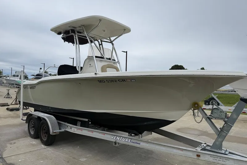 Slide: The Image of 2016 Key West 219 FS boat on trailer, parked outdoors under cloudy sky. - 18