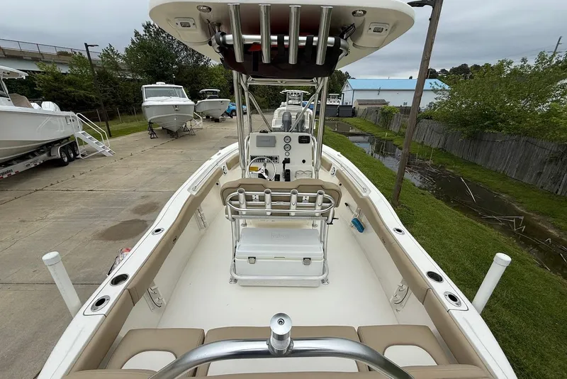 Slide: The Image of 2016 Key West 219 FS boat interior with seating and console, parked outdoors. - 19