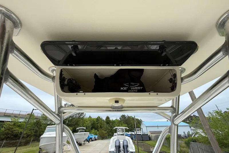 Slide: The Image of 2016 Key West 219 FS boat with open storage compartment, docked outdoors. - 26