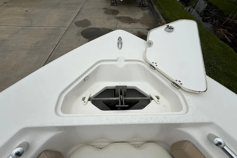 Slide: The Image of 2016 Key West 219 FS boat anchor compartment with open hatch on concrete dock. - 34