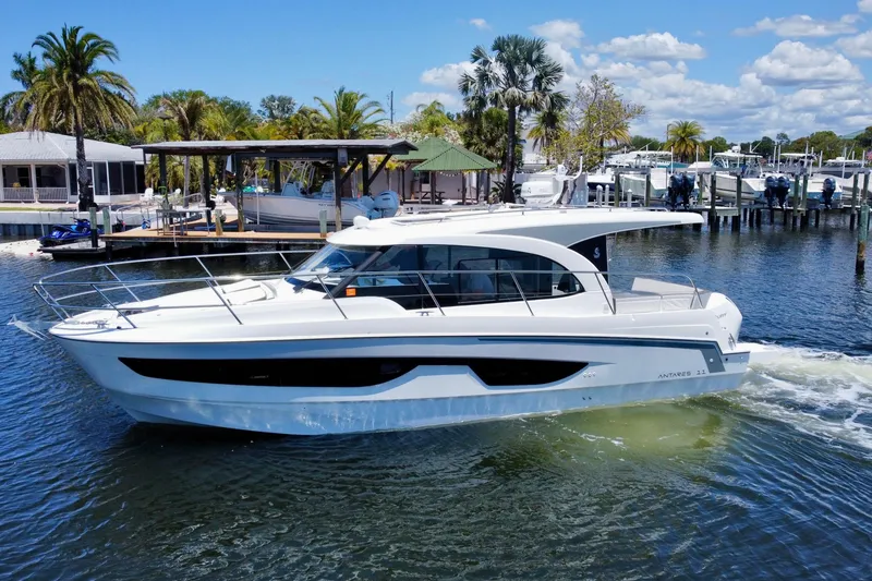 The Image of 2021 Beneteau Antares 11 cruising on a sunny day near a marina. - 0