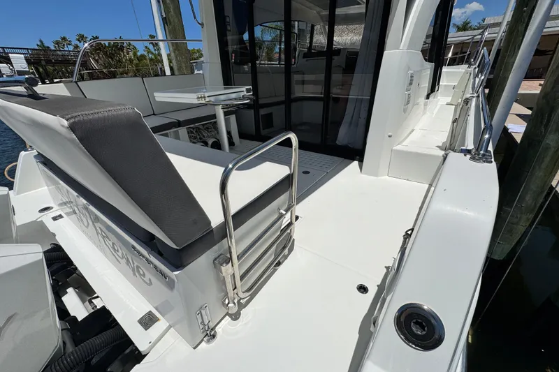 Slide: The Image of 2021 Beneteau Antares 11 boat deck with seating and table, docked under clear skies. - 10