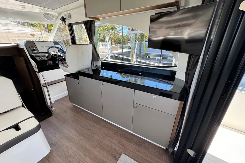 Slide: The Image of Interior of 2021 Beneteau Antares 11 with modern helm, seating, and cabinetry. - 20