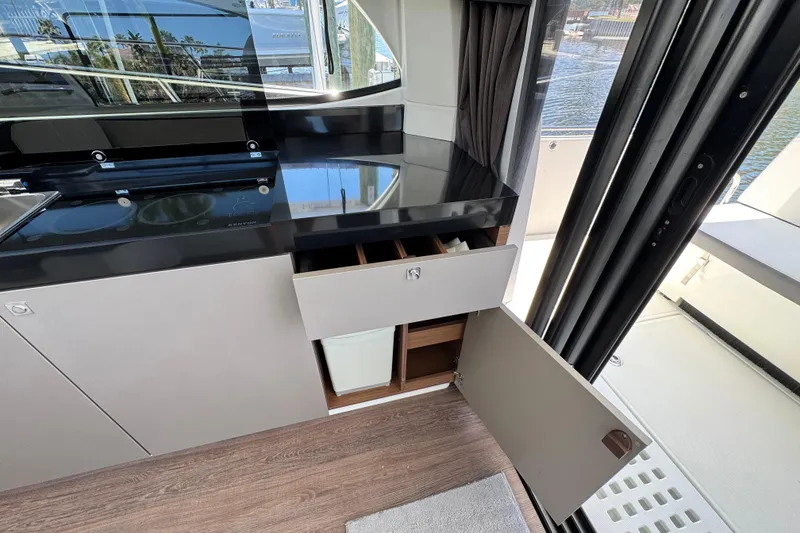 Slide: The Image of Modern kitchen area on a 2021 Beneteau Antares 11 yacht with open cabinets. - 22