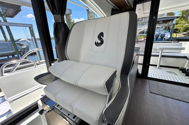 Slide: The Image of Captain's chair on 2021 Beneteau Antares 11 boat, with scenic marina view. - 30