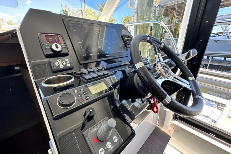 Slide: The Image of Helm of 2021 Beneteau Antares 11 with modern navigation controls and steering wheel. - 32