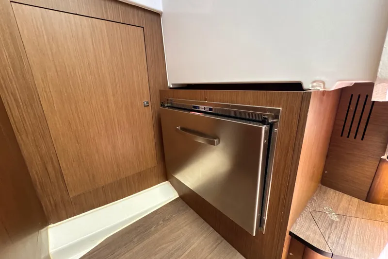 Slide: The Image of 2021 Beneteau Antares 11 interior with wood paneling and stainless steel appliance. - 46