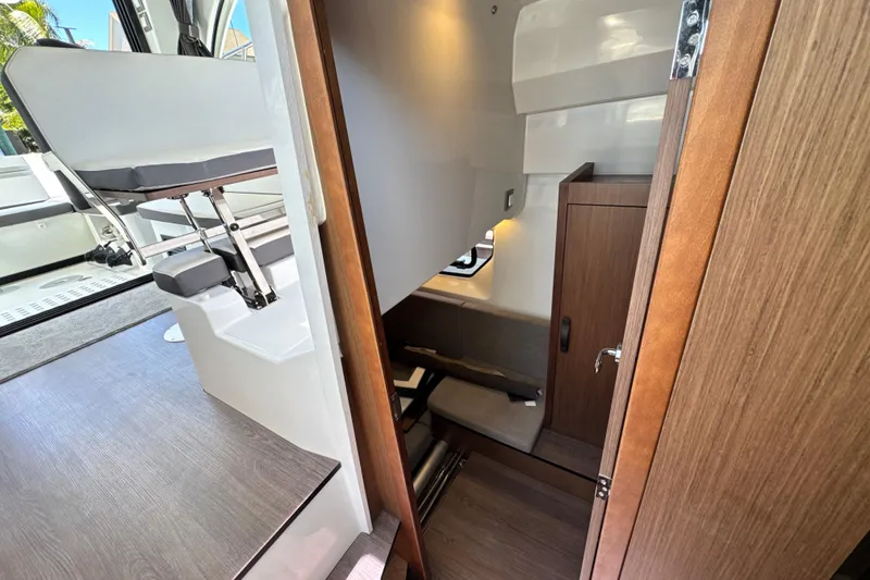 Slide: The Image of Interior cabin view of a 2021 Beneteau Antares 11, featuring seating and wooden finishes. - 58