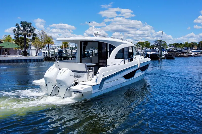 Slide: The Image of 2021 Beneteau Antares 11 cruising in a sunny marina, showcasing sleek design and powerful engines. - 6