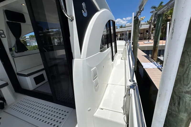 Slide: The Image of 2021 Beneteau Antares 11 yacht docked, showcasing sleek exterior and spacious deck walkway. - 61