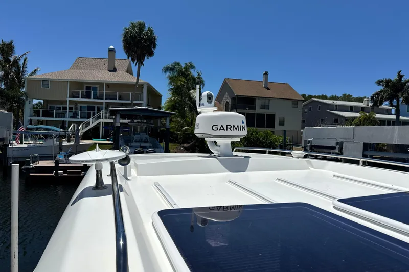 Slide: The Image of 2021 Beneteau Antares 11 yacht docked, featuring Garmin equipment, with waterfront homes in the background. - 65