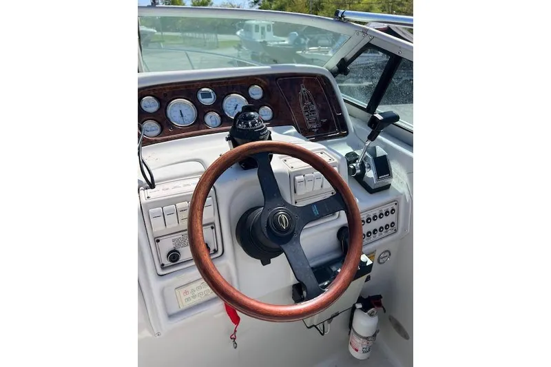 Slide: The Image of Cockpit of a 1997 Crownline 250 CR boat with wooden steering wheel and control panel. - 10
