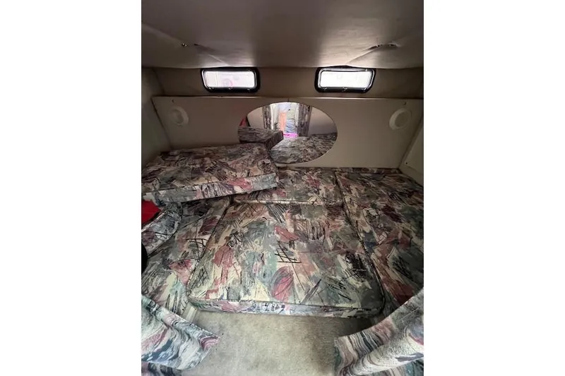 Slide: The Image of 1997 Crownline 250 CR cabin interior with patterned cushions and small windows. - 3