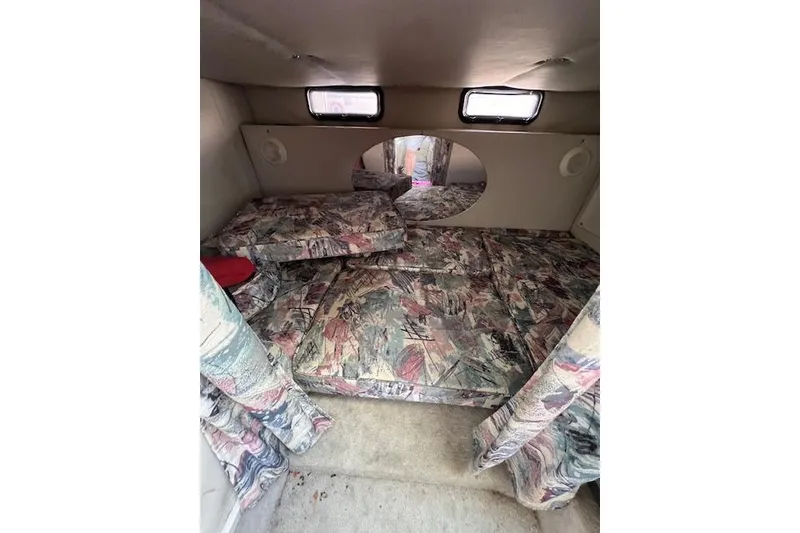 Slide: The Image of Interior cabin of a 1997 Crownline 250 CR boat with patterned cushions and small windows. - 4