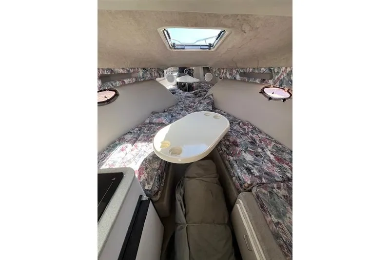 Slide: The Image of Interior of a 1997 Crownline 250 CR boat with floral upholstery and a small table. - 5