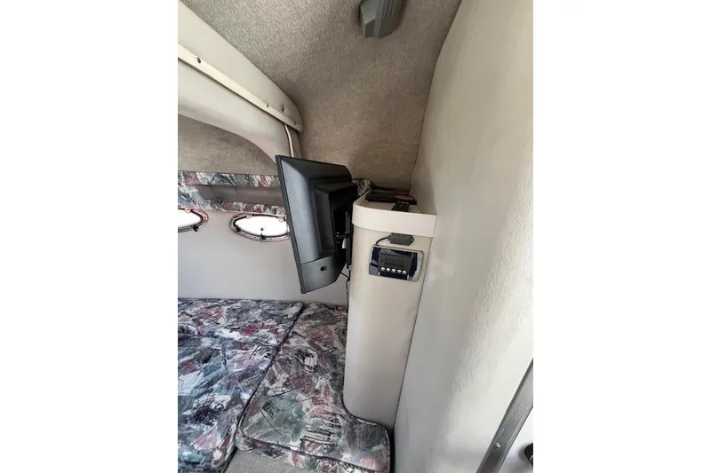 Slide: The Image of 1997 Crownline 250 CR cabin interior with TV and patterned upholstery. - 7
