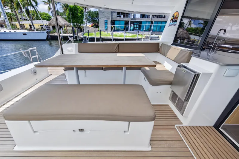 Slide: The Image of Spacious outdoor seating area on 2015 Fountaine Pajot Helia 44 catamaran, featuring cushioned benches and table. - 18