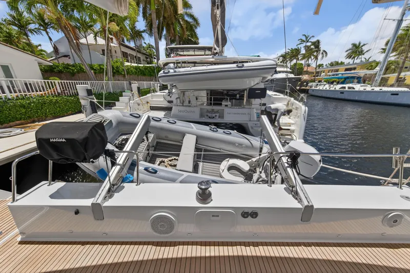 Slide: The Image of 2015 Fountaine Pajot Helia 44 catamaran docked, featuring inflatable dinghy and outdoor seating. - 19