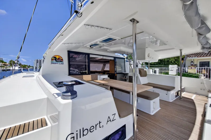 Slide: The Image of 2015 Fountaine Pajot Helia 44 catamaran with spacious deck and seating area, docked by waterfront. - 22