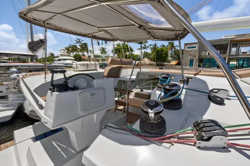 Slide: The Image of 2015 Fountaine Pajot Helia 44 catamaran cockpit with winches and helm, docked in marina. - 24