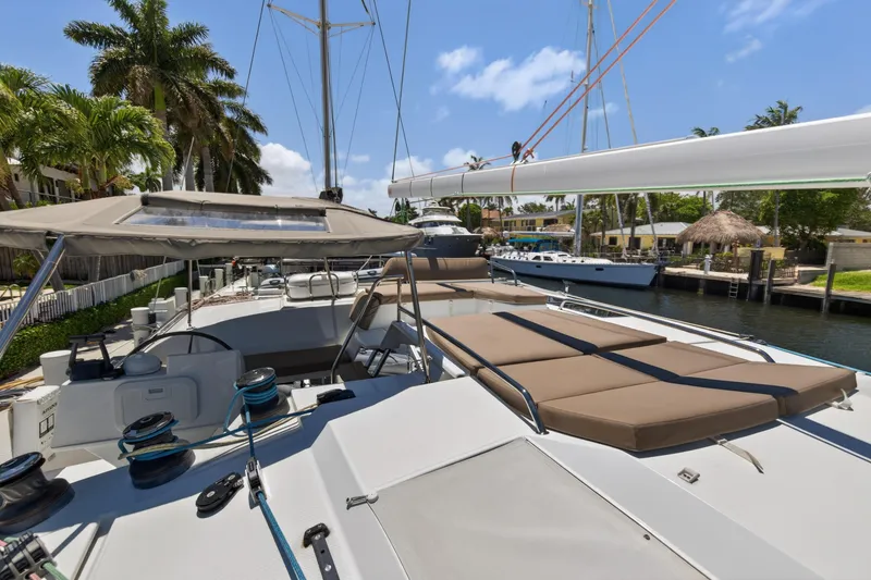 Slide: The Image of 2015 Fountaine Pajot Helia 44 catamaran docked, featuring spacious deck and sunbathing area. - 28