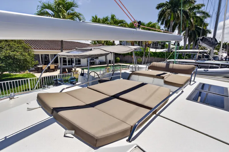 Slide: The Image of 2015 Fountaine Pajot Helia 44 catamaran with sun loungers, docked near tropical greenery. - 31
