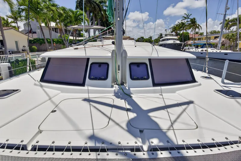 Slide: The Image of 2015 Fountaine Pajot Helia 44 catamaran docked, showcasing sleek deck design and tropical surroundings. - 34