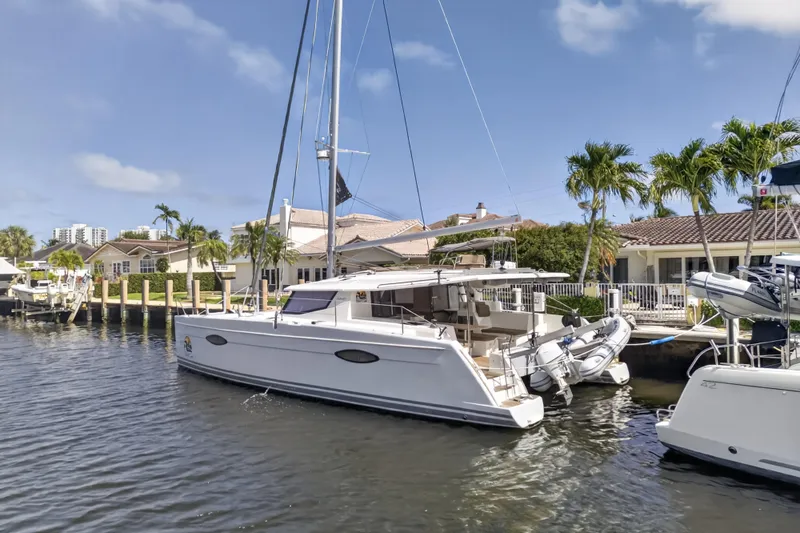 Slide: The Image of 2015 Fountaine Pajot Helia 44 catamaran docked by waterfront homes. - 4