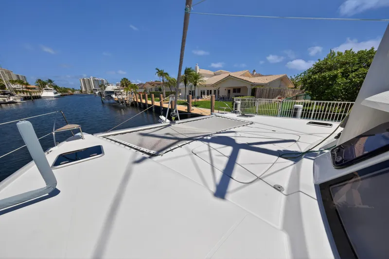 Slide: The Image of 2015 Fountaine Pajot Helia 44 catamaran docked by waterfront homes under clear blue sky. - 42