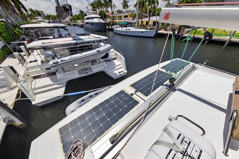 Slide: The Image of 2015 Fountaine Pajot Helia 44 catamaran docked, featuring solar panels and a lifeboat. - 45