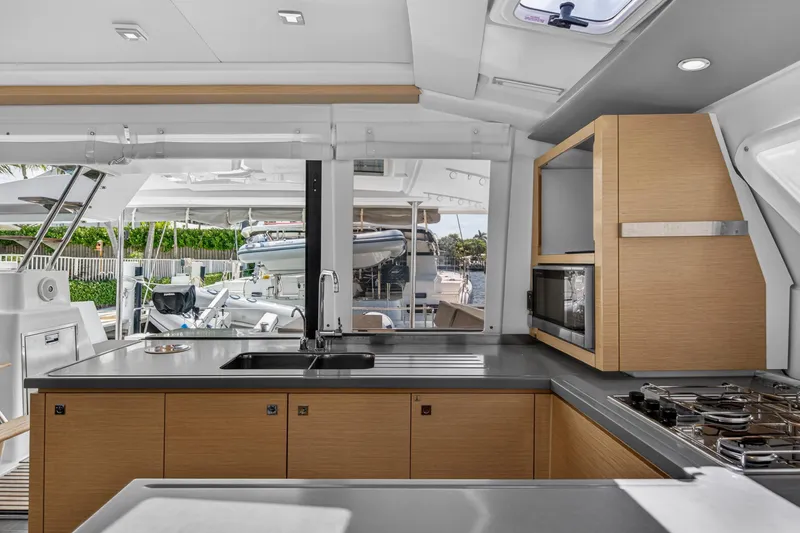 Slide: The Image of Modern kitchen interior on 2015 Fountaine Pajot Helia 44 catamaran, featuring sleek cabinetry and appliances. - 65